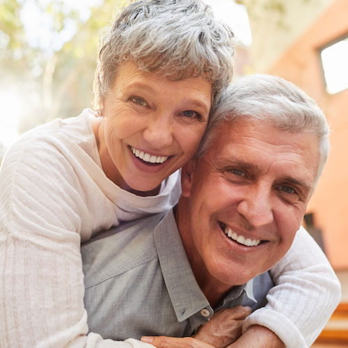 PTERYGIUM Loving mature couple sitting outside on a sunny afternoon